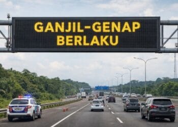 Petugas kepolisian sedang mengawasi aturan ganjil genap arus balik di gerbang tol