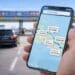 Seorang pengemudi menggunakan smartphone untuk melakukan cara cek tarif tol arus balik 2026