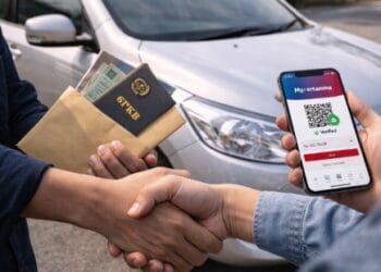 Proses transaksi jual beli mobil bekas antara dua orang yang sedang mengecek dokumen STNK