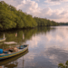 Pemandangan alam yang tenang di Danau Siombak Medan Utara dengan deretan pohon mangrove dan perahu nelayan.
