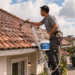 Seorang pria sedang memeriksa posisi genteng guna menerapkan cara mengatasi atap rumah bocor di bagian atas rumah.