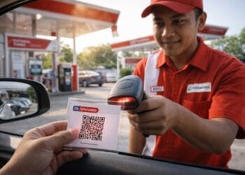 Seorang pengendara menunjukkan QR Code Pertamina yang sudah dicetak kepada petugas SPBU
