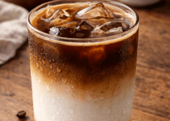 Sajian es kopi susu gula aren yang menyegarkan dengan lapisan warna yang cantik dan estetik.