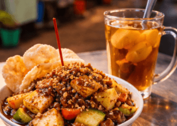 Menu makanan sehat berupa rujak buah segar dan teh jahe hangat di pusat wisata kuliner malam Medan.