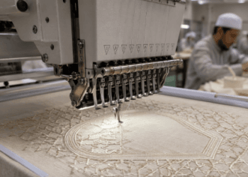 Proses pengerjaan motif bordir geometris pada bagian dada kemeja takwa di pusat bordir baju koko Medan.