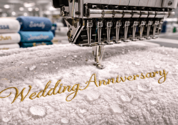 Detail jahitan presisi menggunakan benang emas pada layanan bordir handuk Medan untuk kebutuhan kado premium.