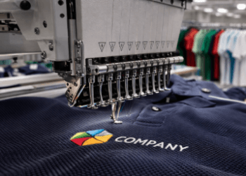 Mesin bordir digital sedang mengerjakan logo perusahaan pada bagian dada pusat bordir kaos polo Medan.
