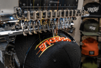 Proses pengerjaan bordir timbul (3D) pada topi baseball menggunakan mesin digital di pusat bordir topi satuan Medan.