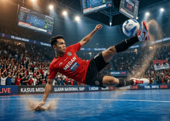 Pemain futsal sedang melakukan teknik tendangan salto secara sempurna untuk mencetak gol ke gawang lawan.