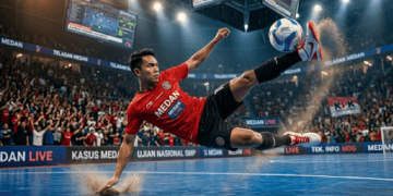 Pemain futsal sedang melakukan teknik tendangan salto secara sempurna untuk mencetak gol ke gawang lawan.