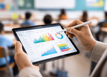 Proses evaluasi hasil TKA oleh tenaga pendidik menggunakan perangkat digital untuk memantau grafik perkembangan siswa.