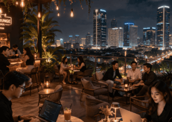 Suasana gaya hidup modern masyarakat Medan di kafe atap gedung yang memperlihatkan keindahan pemandangan kota di malam hari.