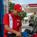 pegawai pertamina sedang melakukan pelayanan kepada penbeli bahan bakar