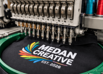 Mesin bordir digital otomatis sedang mengerjakan logo presisi pada pusat jasa jahit topi Medan.