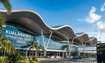 Pemandangan udara Bandara Medan Kualanamu yang menunjukkan kemegahan terminal dan area parkir yang luas.