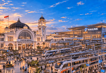 Fasad megah Stasiun Kereta Api Medan yang memadukan arsitektur kolonial bersejarah dengan fasilitas modern kereta bandara.