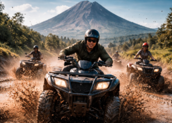 Keseruan wisatawan saat bermain ATV Berastagi menaklukkan jalur berlumpur dengan latar belakang pegunungan.