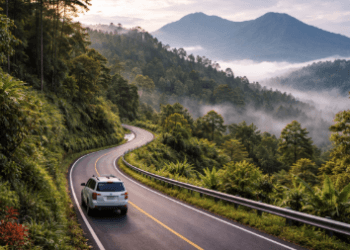 Suasana jalanan berkelok yang asri selama melakukan perjalanan Medan ke Berastagi melewati kawasan perbukitan.