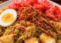 Satu porsi Lontong Medan Komplit dengan siraman kuah tauco dan berbagai macam topping pelengkap.