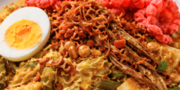 Satu porsi Lontong Medan Komplit dengan siraman kuah tauco dan berbagai macam topping pelengkap.