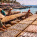 Proses penjemuran ikan asin tradisional yang menjadi penggerak utama ekonomi kampung nelayan.
