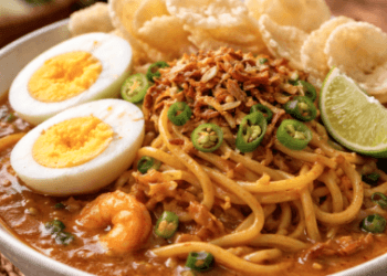 Seporsi Mie Rebus Belawan yang kaya akan rempah dengan siraman kuah udang kental dan taburan bawang goreng.