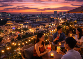 Suasana indah di salah satu rooftop cafe Medan saat matahari terbenam dengan latar belakang lampu kota.