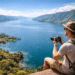 Wisatawan sedang mengabadikan momen di salah satu spot foto di Danau Toba yang memiliki pemandangan lanskap spektakuler.