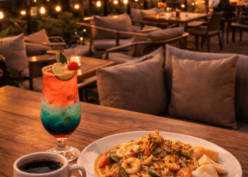 Suasana santai di salah satu Spot Makan Rooftop Medan yang menawarkan pemandangan gedung-gedung tinggi saat matahari terbenam.