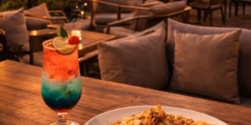 Suasana santai di salah satu Spot Makan Rooftop Medan yang menawarkan pemandangan gedung-gedung tinggi saat matahari terbenam.