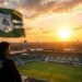 A breathtaking sunrise over the newly renovated Teladan Stadium. The PSMS Medan flag waves proudly at the highest point. Golden hour lighting, cinematic, high resolution, 8k, no blur.