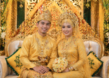 Pasangan pengantin yang tampil anggun dalam balutan busana Pernikahan Adat Melayu Medan.