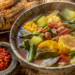 Semangkuk hangat hidangan dari panduan Resep Sayur Asem Jakarta yang disajikan bersama sambal dadak ulek kasar dan ikan asin goreng garing.