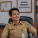 Foto pegawai pemerintah yang merasa lega dan tersenyum kembali bekerja di meja kantor setelah mengikuti ujian seleksi aparatur sipil negara,