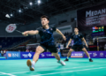 Suasana dalam ruangan gedung olahraga bulu tangkis dengan lapisan lantai karpet hijau yang bersih di salah satu lapangan badminton di Medan