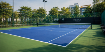 Keindahan tatanan lapangan tenis luar ruangan dengan permukaan berwarna biru terang yang bersih di salah satu lapangan tenis di Medan