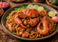 Sajian sepiring mie aceh kuah kental dengan topping kepiting besar yang sangat lezat di salah satu warung mie aceh di Medan yang ramai