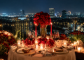 Keindahan tatanan meja makan malam romantis dengan lilin menyala dan latar belakang kerlip lampu kota di salah satu tempat dinner romantis di Medan