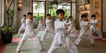 Suasana latihan kedisiplinan anak-anak berpakaian putih yang sedang memperagakan gerakan pukulan di salah satu tempat latihan karate di Medan