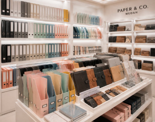 Jajaran binder kulit minimalis berwarna cokelat dan map organizer plastik warna pastel yang tersusun sangat rapi di dalam salah satu toko binder di Medan