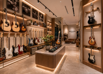 Jajaran gitar akustik kayu cokelat dan gitar listrik modern yang tergantung sangat rapi di dinding salah satu toko gitar di Medan