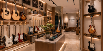Jajaran gitar akustik kayu cokelat dan gitar listrik modern yang tergantung sangat rapi di dinding salah satu toko gitar di Medan