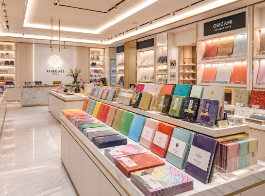 Jajaran kertas karton manila warna pastel dan tumpukan kertas origami bermotif estetik yang tersusun sangat rapi di dalam salah satu toko kertas warna di Medan