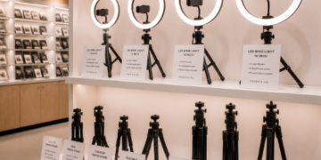 Jajaran tempat lampu cincin bahan plastik polikarbonat tebal untuk konten video dan alat ring light selfie minimalis berbagai ukuran diameter lampu yang tersusun sangat rapi di dalam etalase toko perlengkapan studio