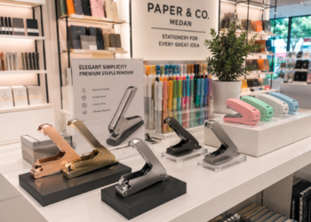 Jajaran alat pembuka staples model jepit besi dan pencongkel kawat hekter minimalis yang tersusun sangat rapi di dalam etalase toko perlengkapan kantor