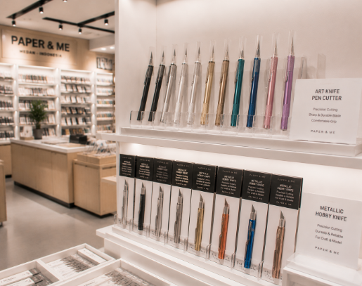 Jajaran tempat pisau silet seni bahan logam dengan tekstur anti-slip untuk ukiran kertas dan alat art knife pen cutter minimalis berbagai bentuk mata pisau yang tersusun sangat rapi di dalam etalase toko perlengkapan hobi