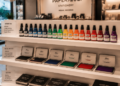 Jajaran botol tinta stempel premium berbagai warna dan alat bak stempel logam minimalis yang tersusun sangat rapi di dalam etalase toko perlengkapan stasioneri kantor